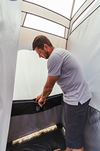 A man standing inside of a Bushnell Shower Tent with Instant Setup Technology.