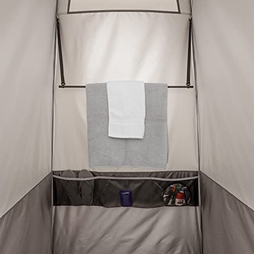 A Bushnell Shower Tent with Instant Setup Technology hanging on a metal rack.