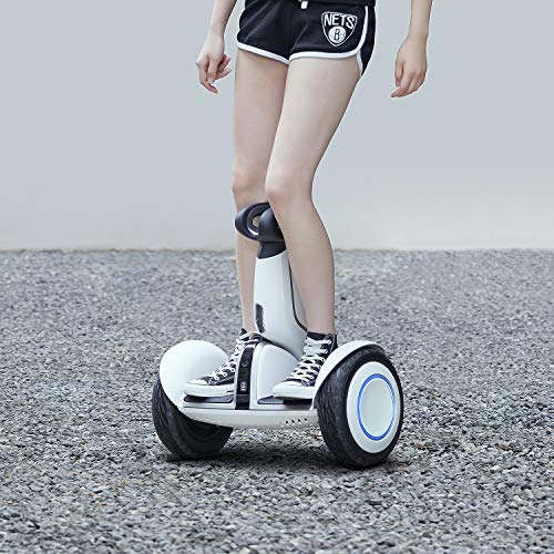 A woman is standing on a Segway Ninebot S-Plus Self-Balancing Electric Scooter: 12.5 Mph, 28 Mile Range.