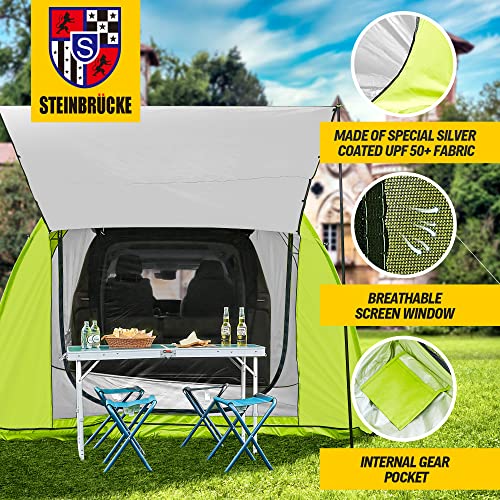 A STEINBRÜCKE SUV Car Camping Tailgate Tent with a table and chairs in it.