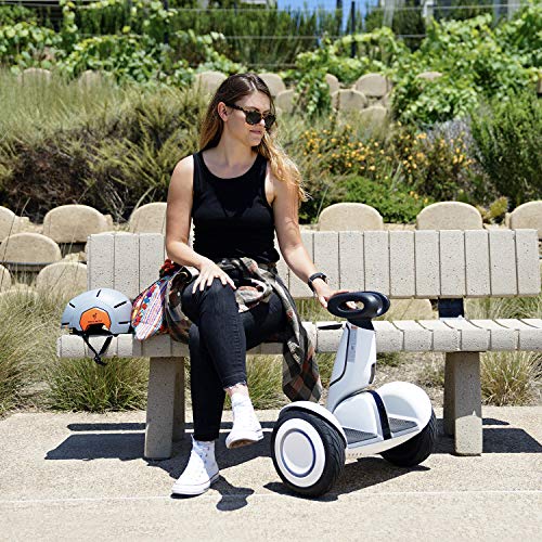 A woman sitting on a bench with a Segway Ninebot S-Plus Self-Balancing Electric Scooter: 12.5 Mph, 28 Mile Range.